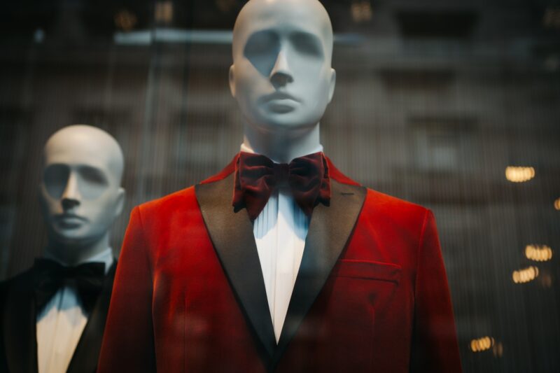Store mannequins in fashionable tuxedos in a shop window